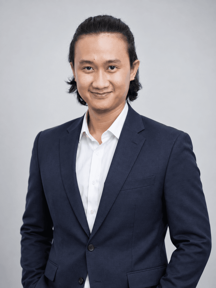 Hasil AI gaya Clean Corporate: pria yang sama memakai blazer navy dan kemeja putih tanpa dasi, latar studio abu-abu polos, pencahayaan lembut