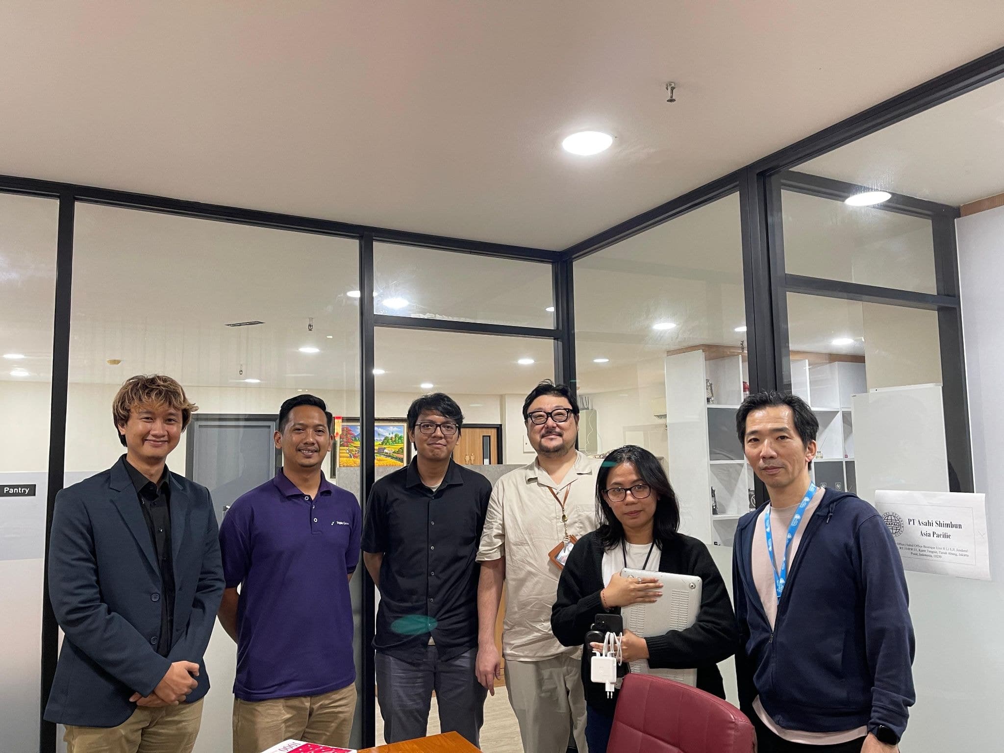 Prasetyo berfoto bersama tim klien di kantor mereka