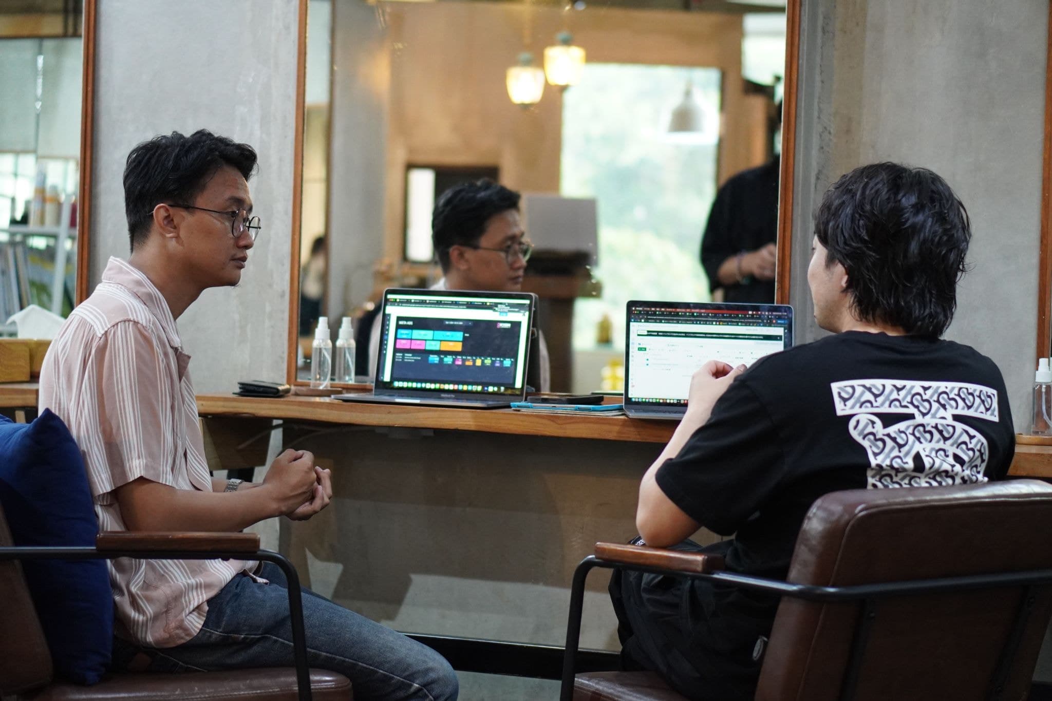 Prasetyo meeting bersama klien di sebuah kafe, laptop terbuka di meja